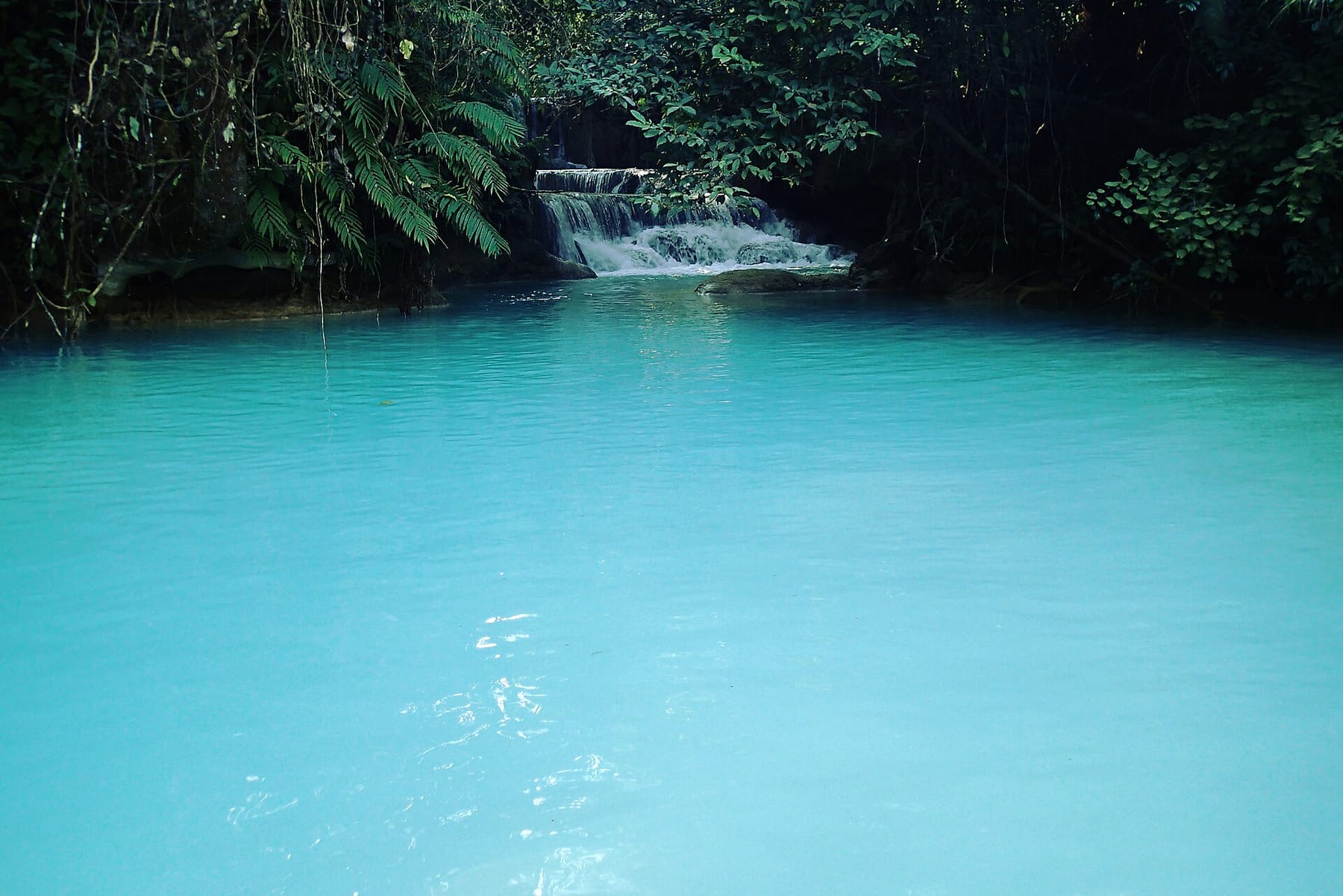 A turquoise pool below a small cascade at Kuang Si, near Luang Prabang, Laos